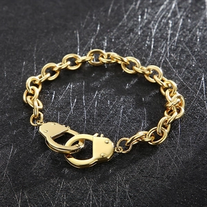 Detailed close-up of golden handcuffs clasp and bold chain on a grey background