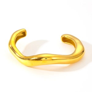 Polished gold wavy stainless steel open bangle bracelet for women on white background