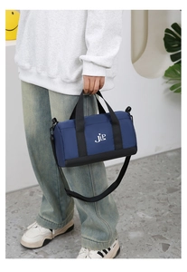 Close-up of blue nylon pillow bag featuring white JIP logo and adjustable black straps