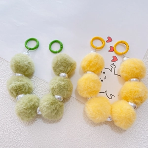 Detail of green and yellow plush ball phone charms with faux pearl beads and ring clips