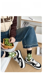 Detail showing green polka dot cotton socks with a comfortable rolled cuff and soft fabric