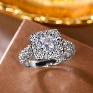 Macro shot of cushion cut gemstone ring with diamond halo and pave setting details