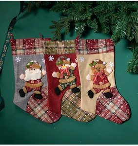 Three decorative Christmas stockings with Santa, Snowman and Reindeer on green background