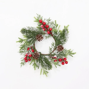 Close-up of frosted pine needles with red berries and snow-covered pine cones on wreath