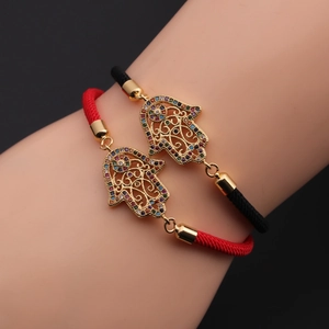 Detail of red and black Hamsa hand bracelets with colorful zircon stones on wrists