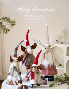 Detail view of 4 varied Nordic Christmas reindeer dolls with tall hats on white fabric