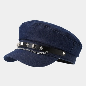 Detail of navy cadet hat with denim texture, silver chain, and metallic star rivets