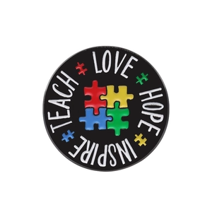 Rainbow puzzle enamel pin with Teach Love Hope Inspire text on a black circular base