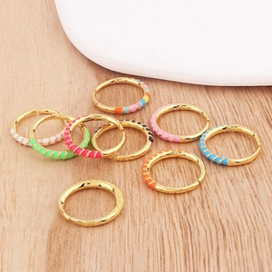 Colorful enamel adjustable open rings in gold finish displayed on a wooden surface