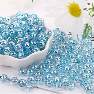 Dettaglio di perle acriliche blu chiaro da 8 mm con glitter cangianti in una ciotola