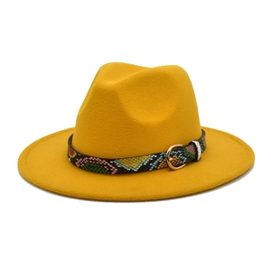 Detail of yellow wool fedora hat featuring a snakeskin leather band and gold buckle