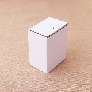 Close-up of a white corrugated cardboard gift box with a round E label on a woven texture