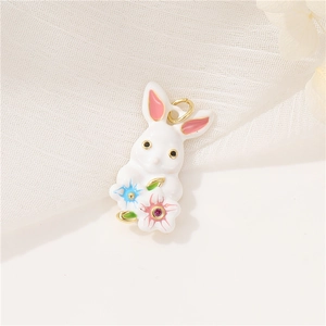 Close-up of white enamel rabbit charm with pink ears and floral base details