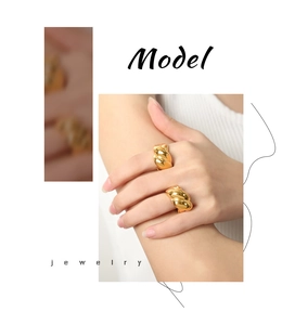 Detailed close-up of golden twisted croissant ring showing polished metal texture on hand