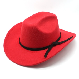 Chapeau de cowboy en feutre rouge avec ruban noir décoratif et large bord sur fond blanc