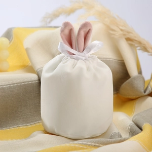Close-up of white velvet Easter bunny ear gift bag with elegant ribbon drawstring
