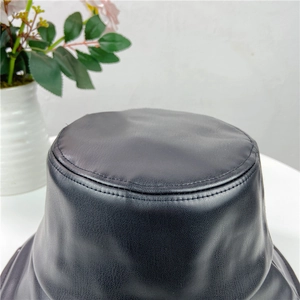 Top view showing textured black faux leather and neat stitching of the bucket hat