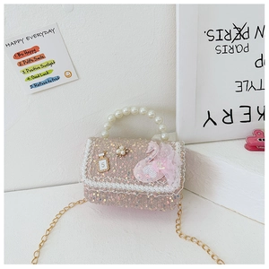 Close-up of pink girls' sequin bag with pearl handle, gold chain and swan patch