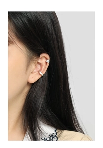 Close-up of irregular textured silver ear cuffs worn on model's ear for non-pierced look