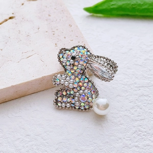Détail d'une broche lapin avec strass arc-en-ciel et une perle blanche à la queue