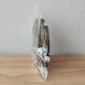 Detail einer Halloween-Perlengirlande mit schwarz-weißen Holzperlen und Juteschnur