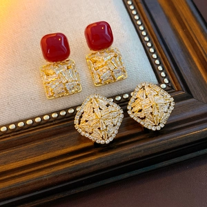 Macro shot of 18K gold earrings with square red stone and pave-set cubic zirconia
