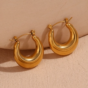 Detailed close-up of chunky gold-plated U-shaped hoop earrings with a polished finish