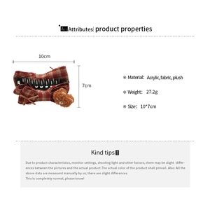 Detail view of acrylic hair claw with red plaid fabric and plush bear decoration