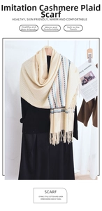 Detail of soft beige cashmere-like knit fabric with colorful plaid patterns and tassels
