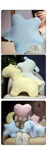Gros plan d'oreillers en peluche douce en forme d'étoile lune et animaux tons pastel
