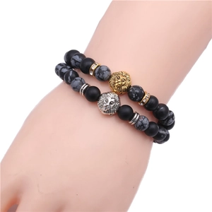 Detailed view of matte black and snowflake stone beads with gold and silver lion heads