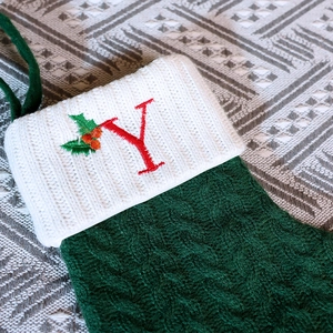 Forest green knitted Christmas stocking with white cuff and red embroidered letter Y