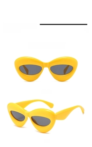 Close-up of chunky yellow cat-eye sunglasses with thick frames and dark lenses