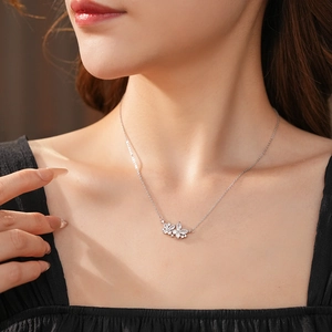 Gros plan d'un collier floral en argent serti de zircons sur le cou d'un mannequin