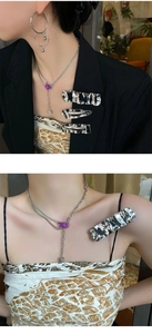 Close-up of silver metal hairpins with wave texture and layered necklace on model