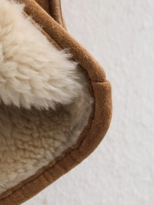 Detail shot of warm sherpa lining and brown jacket fabric showing soft plush texture