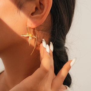 Detail view of a vintage iris flower earring worn by a model in soft natural sunlight