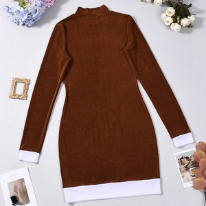 Dettaglio vestito in velluto marrone a collo alto con patchwork bianco su polsini e orlo