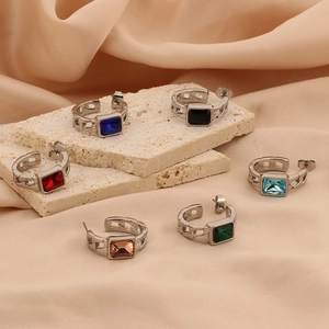 Detailed view of rectangular gemstone hoop earrings on a textured stone base