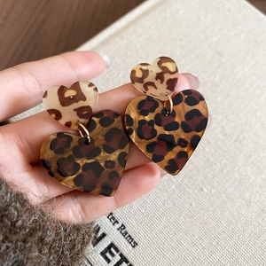 Detailaufnahme von Acryl-Herzohrringen mit Leopardenmuster für Textur und Größe