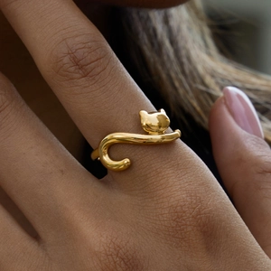 Detailed close-up of a polished gold cat-shaped adjustable ring worn on a finger
