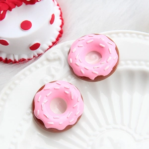 Macro shot of two pink glazed mini donut resin charms for DIY craft phone case accessories