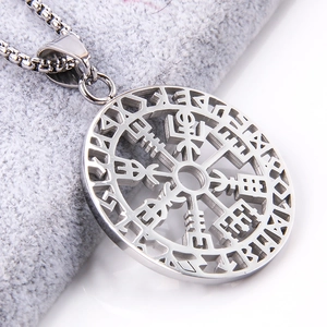 Macro detail of silver stainless steel viking compass pendant with hollow out pattern