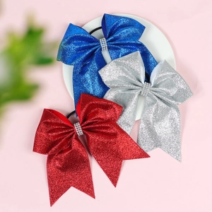 Detail of red, blue and silver glitter bow hair ties with central rhinestone accents