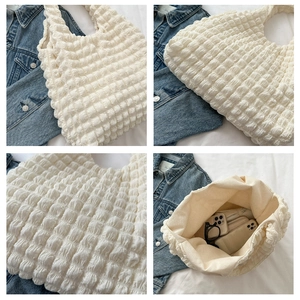 Vue détaillée du sac en tissu blanc à texture popcorn montrant l'espace intérieur