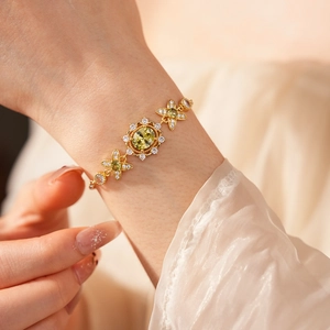 Vue détaillée d'un bracelet vintage doré avec zircon vert ovale et motifs floraux