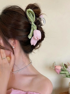Detail der Haarklammer mit rosa Tulpe aus Stoff, getragen für eine elegante Hochsteckfrisur