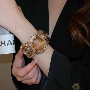 Détail d'un bracelet manchette doré torsadé orné d'une grande pierre ambre taillée