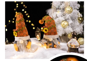 Close-up of autumn gnomes with orange plaid hats and sunflowers in warm festive decor