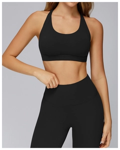 Side view of black cross-back sports bra and high-waist yoga leggings on model